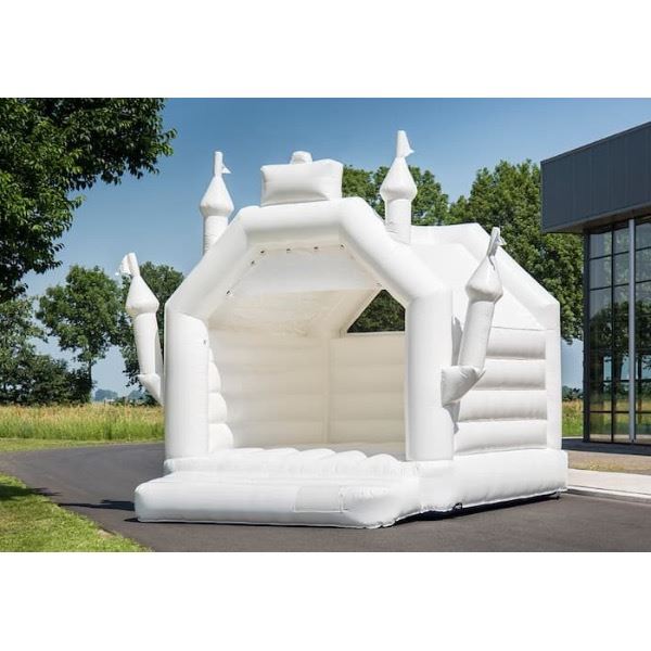 Luxe wit springkasteel tijdens een trouwfeest